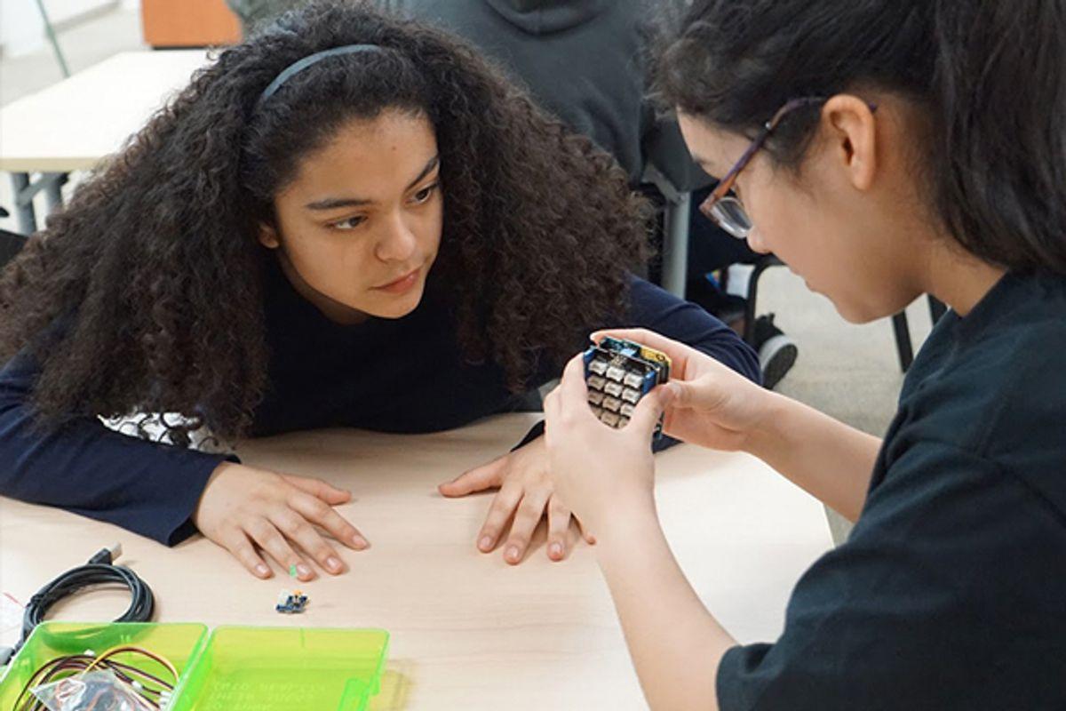 Two students of color looking at an electronic together at iUrban Teen in Vancouver, Washington