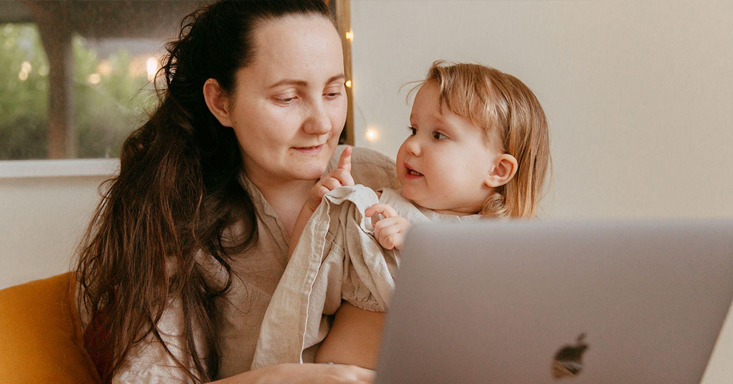 A white woman and a small child sitting in front of a laptop