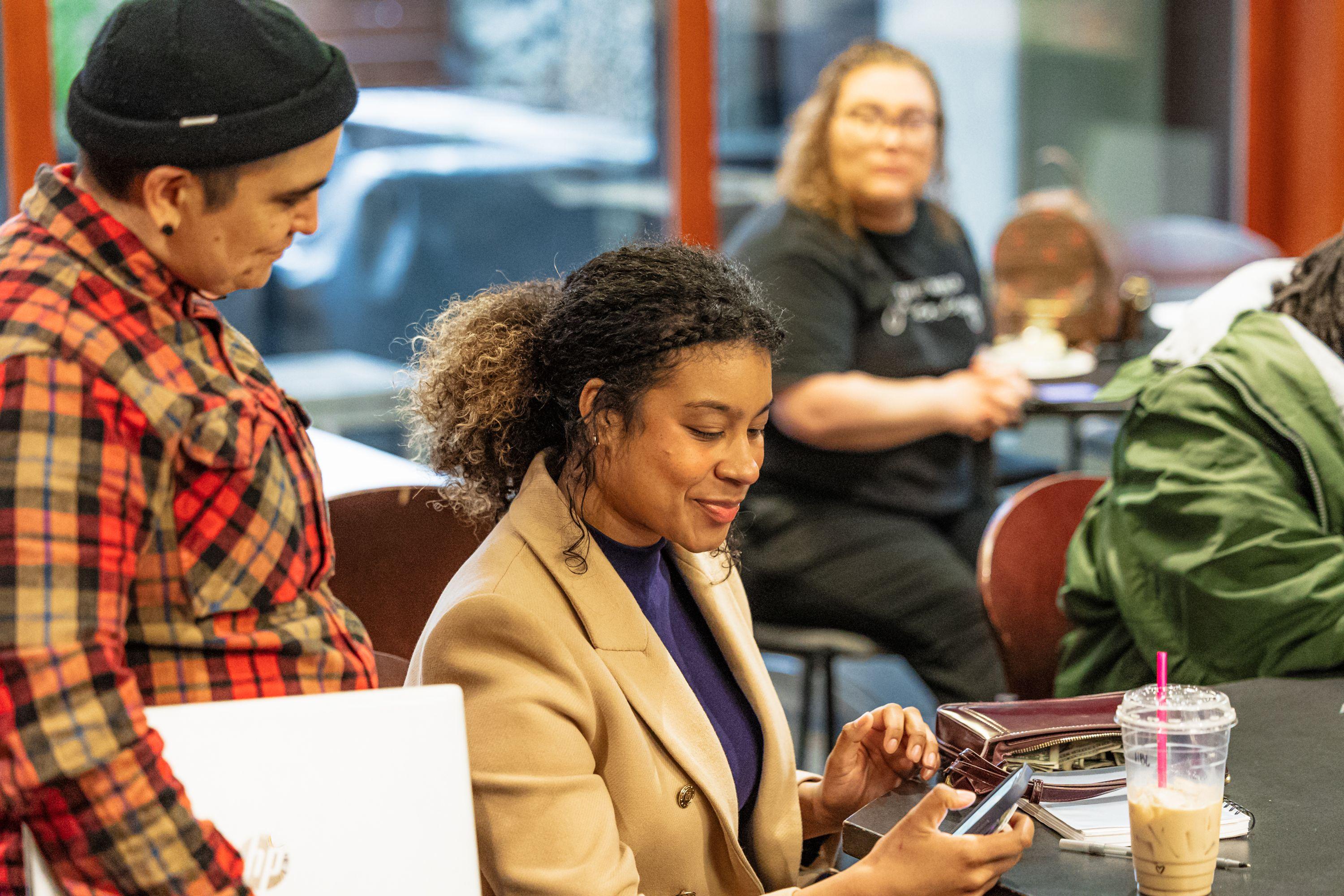 Southwest Washington Equity Coalition, SWEC, during a Vancouver Community Leadership Institute meeting. Two people looking at a phone together smiling slightly