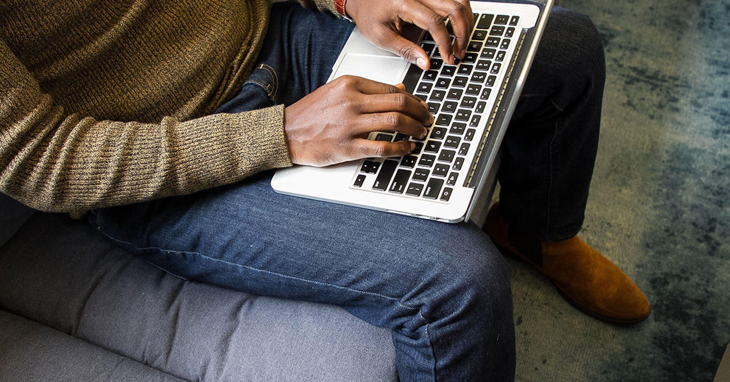 Black person's hands on a laptop keyboard