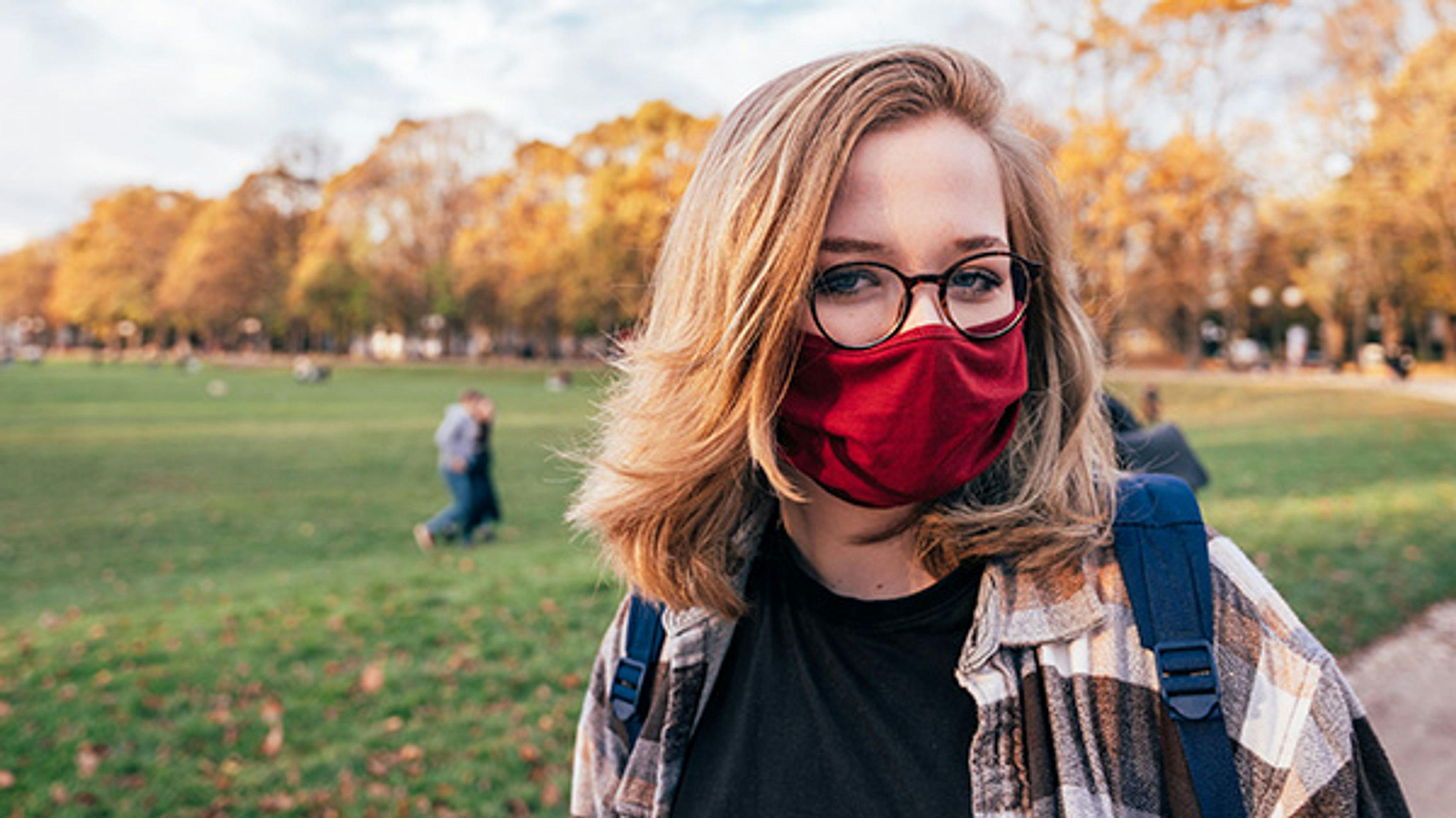 A student wearing a face mask standing outside