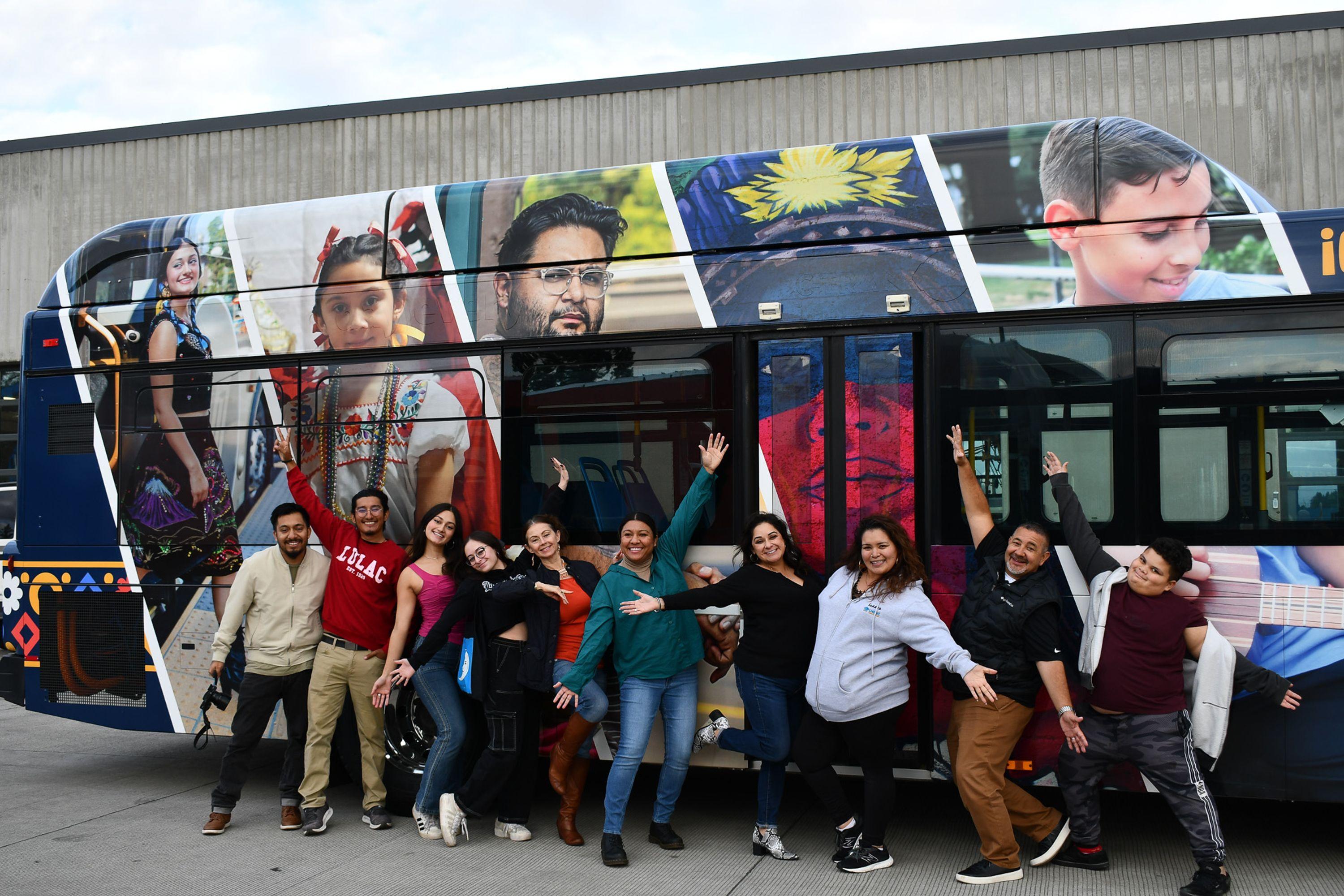 Several Hispanic people proudly displaying the bus they took part in wrapping in partnership with CTRAN and LULAC. Made to celebrate Hispanic Heritage Month