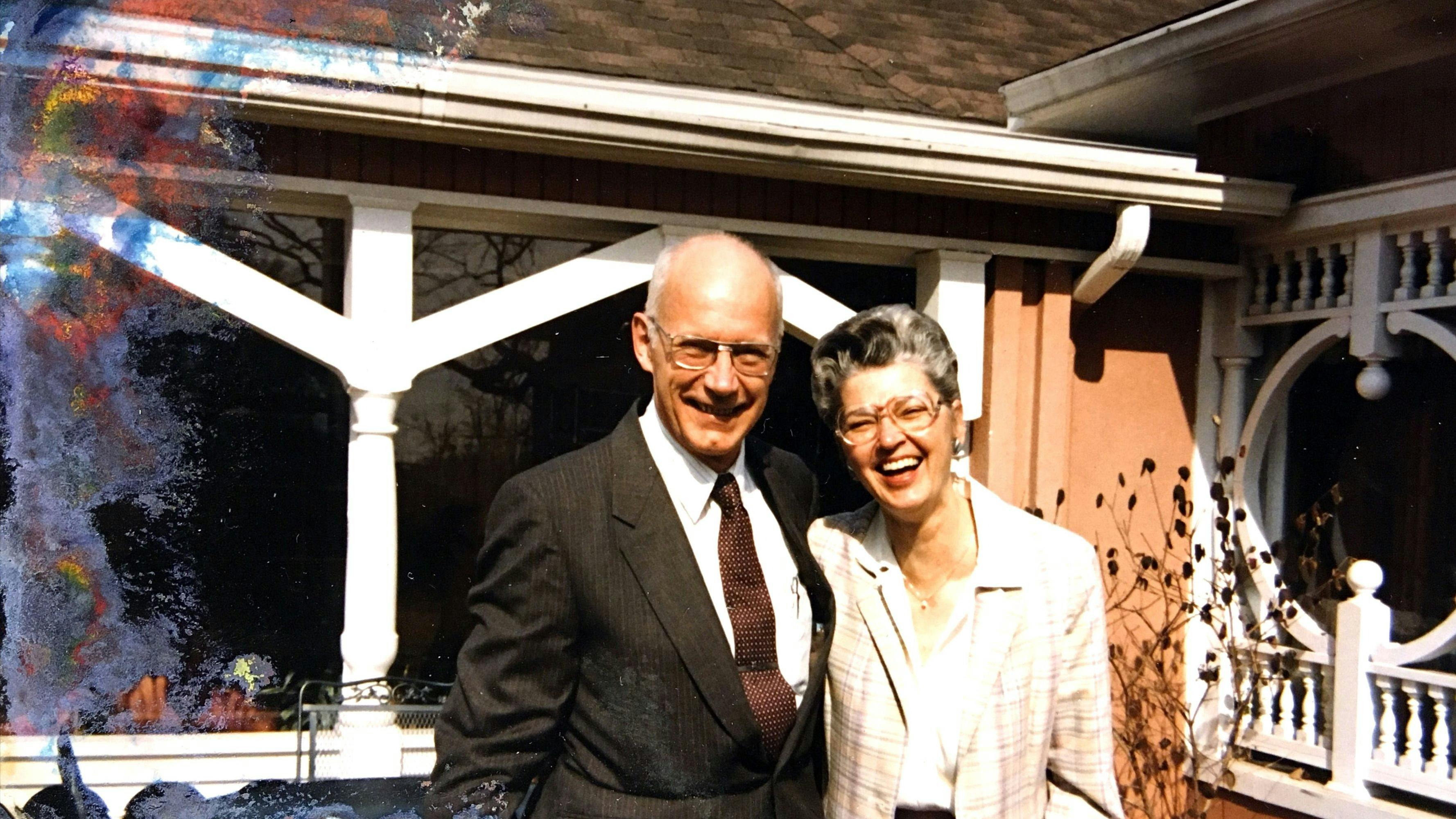 Bill and Catharine Byrd standing in front of their house smiling at the camera