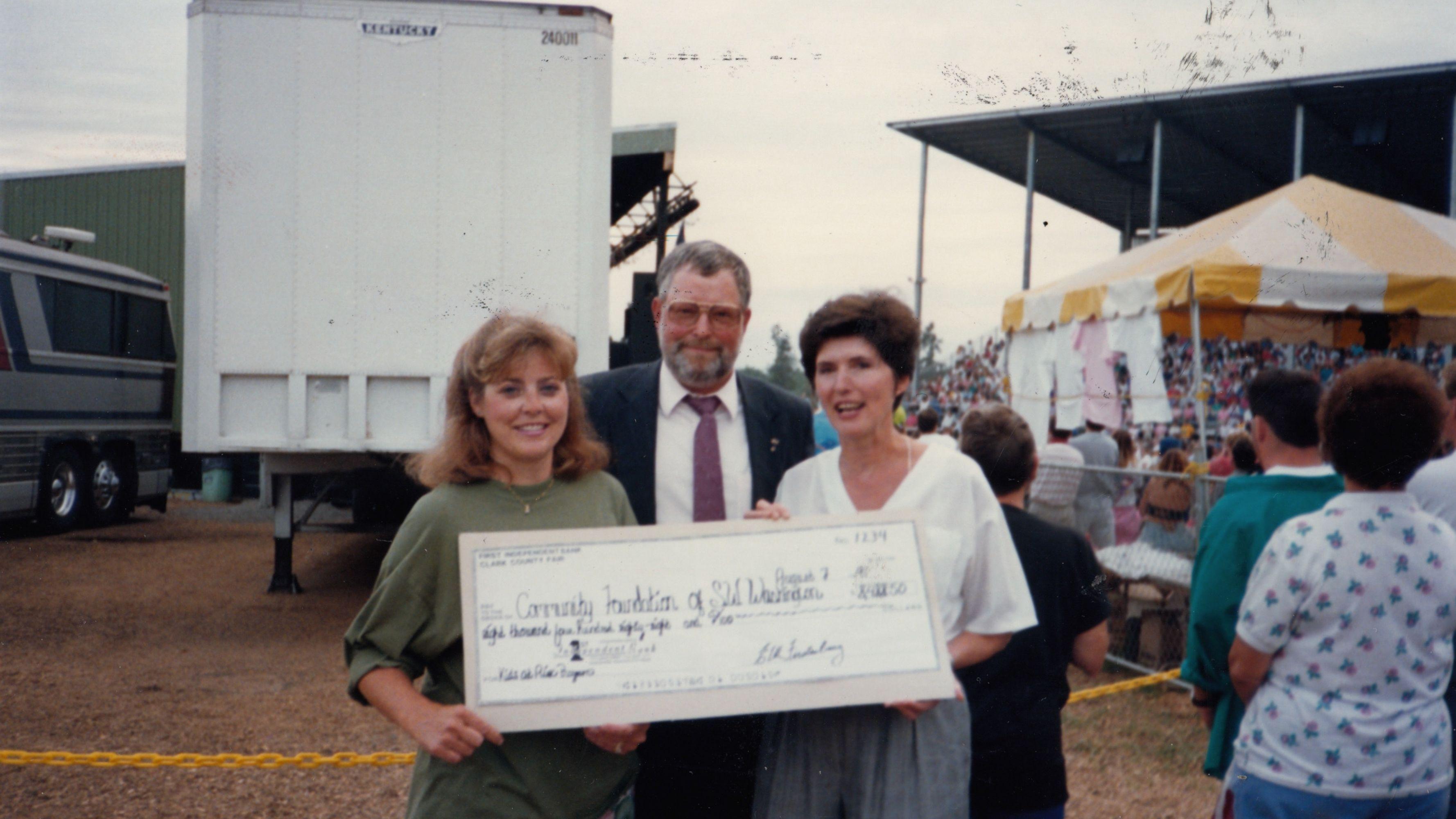 Three people holding an oversized check made out to the Community Foundation