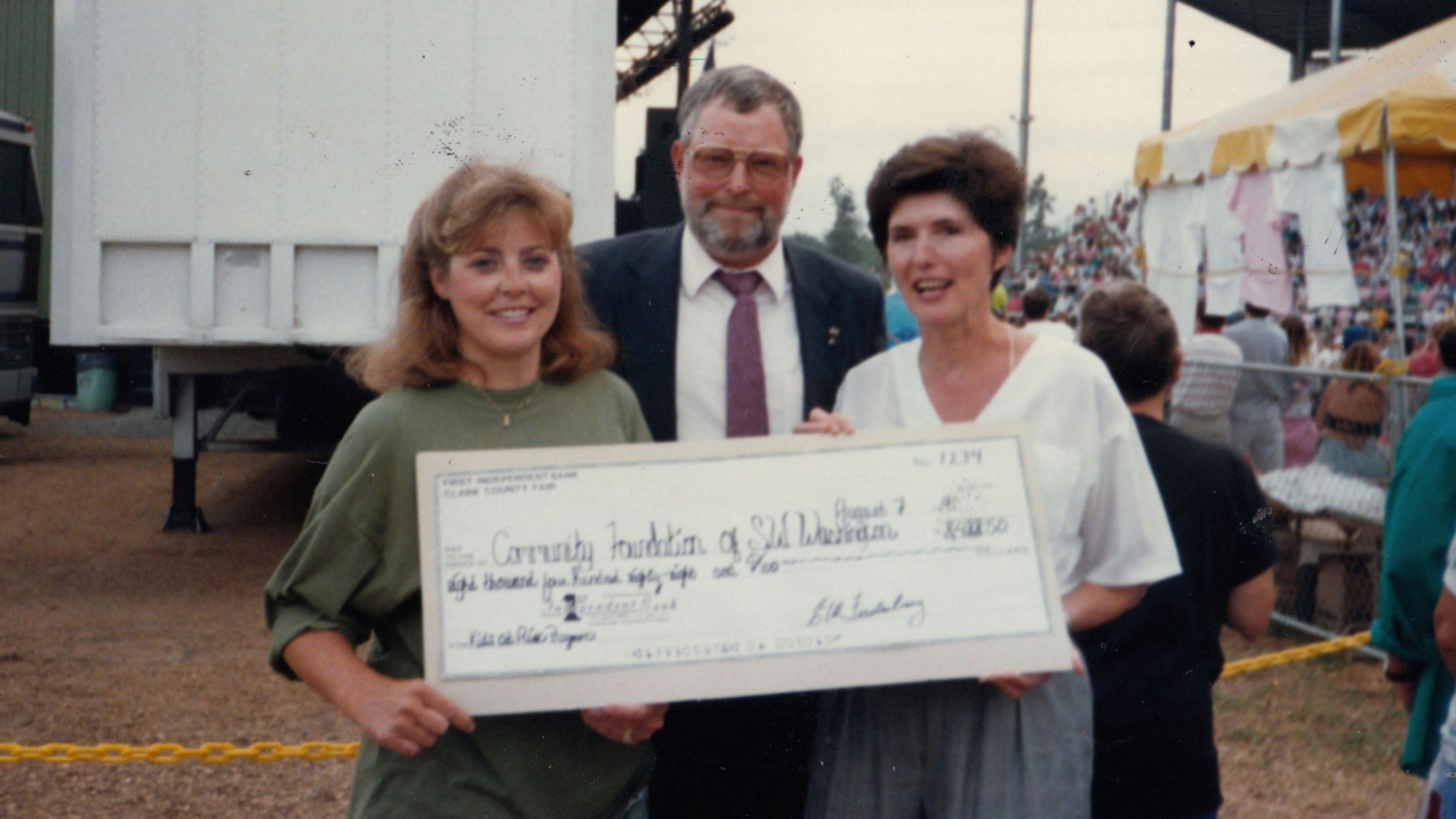 Three people holding an oversized check made out to the Community Foundation