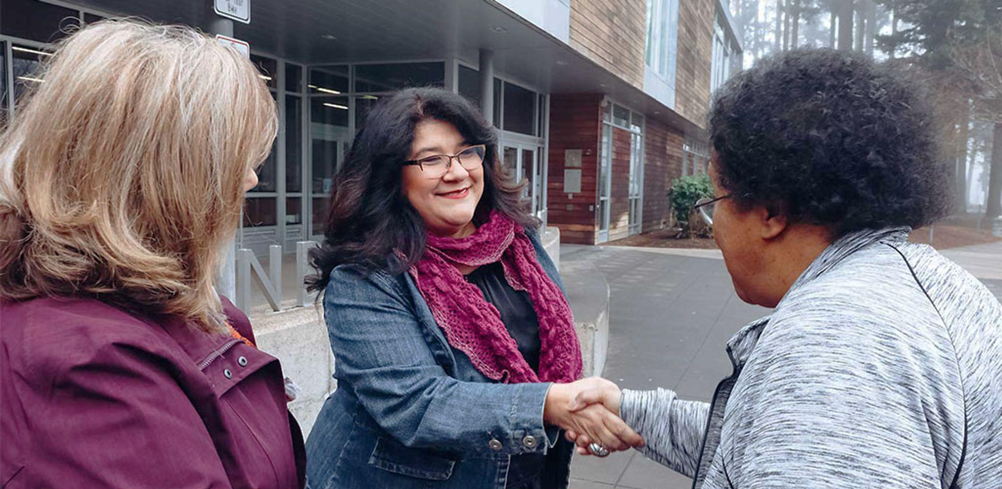 Diana Perez shaking hands with founders of SWEC