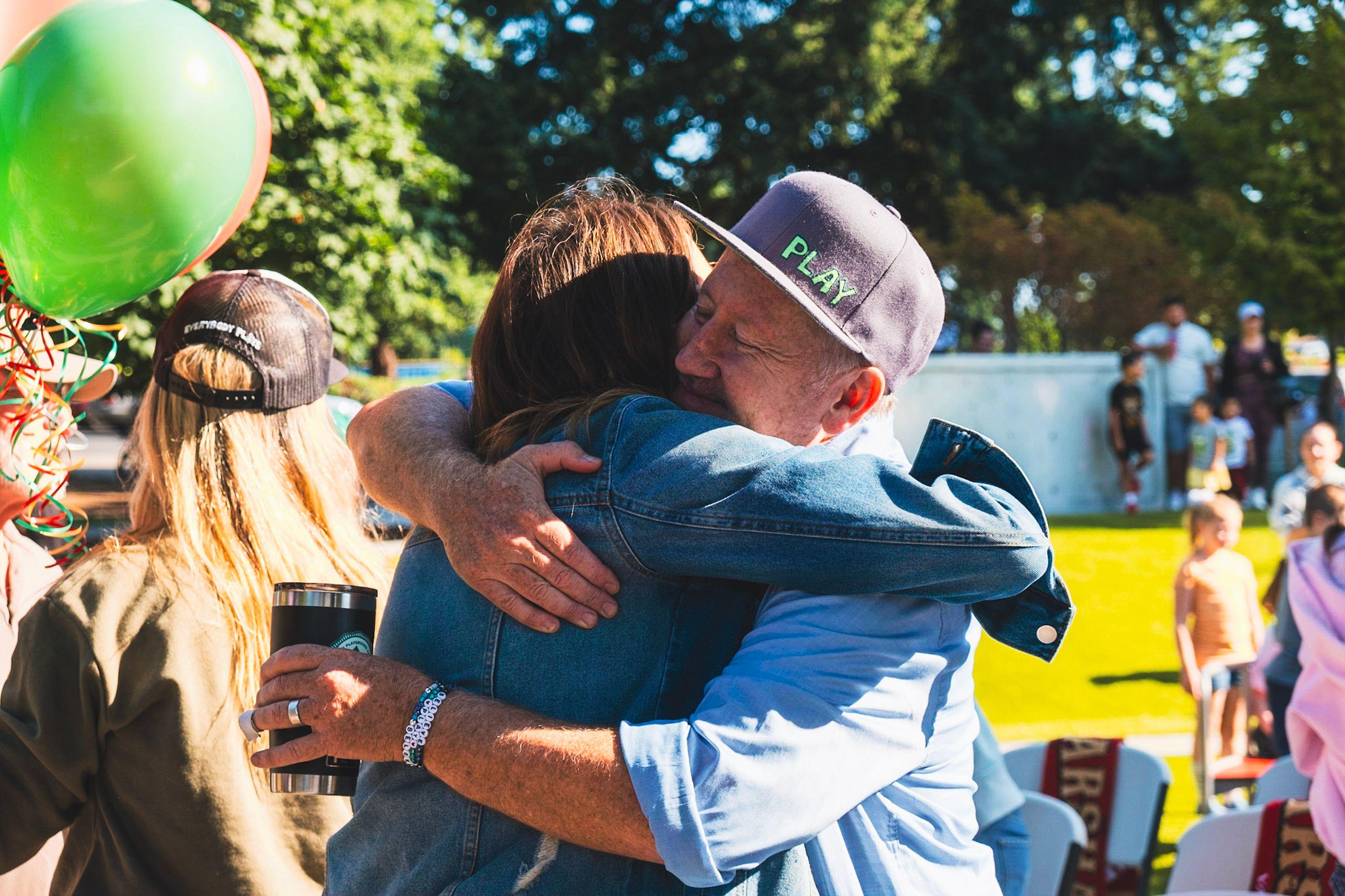 G.Q. Cody Goldberg, founder of Harper's Playground, hugging someone during the Marshall Park Ribbon Cutting Ceremony.