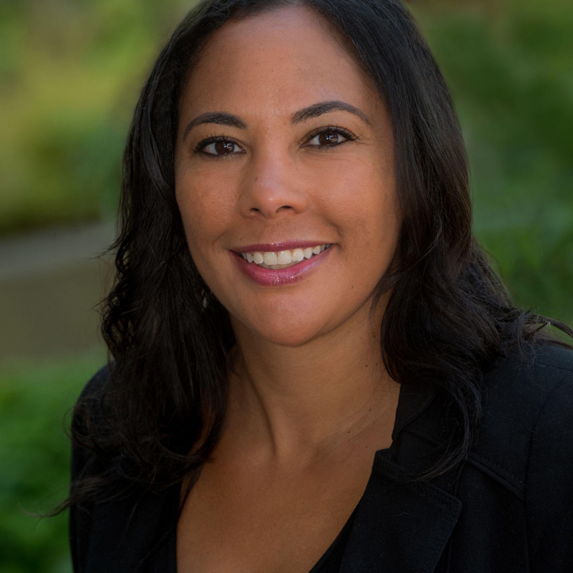 A professional headshot of Ursula Arlauskas standing outdoors