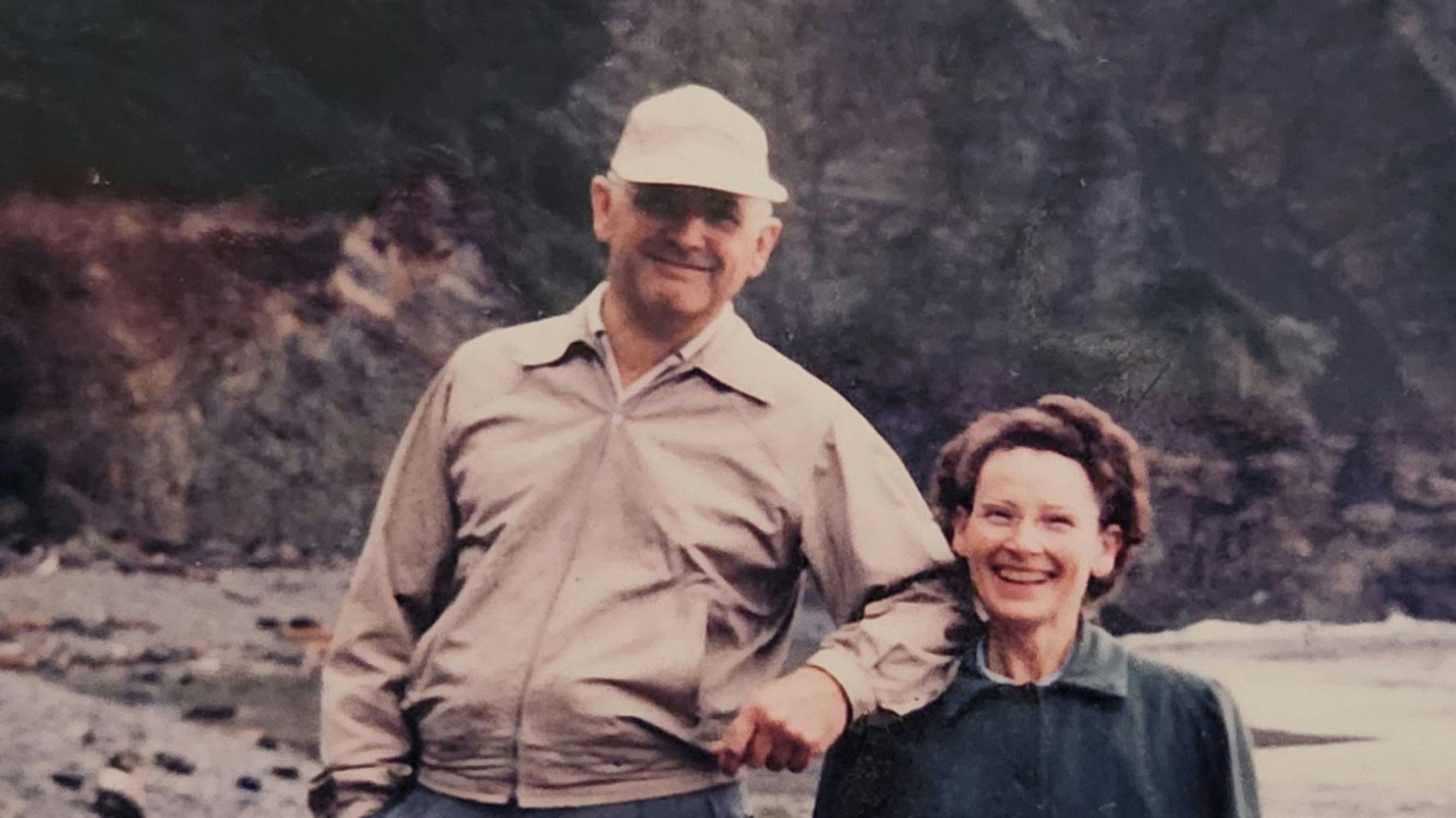 Carl and Myrtle Butler standing next to each other on a river shore smiling at the camera