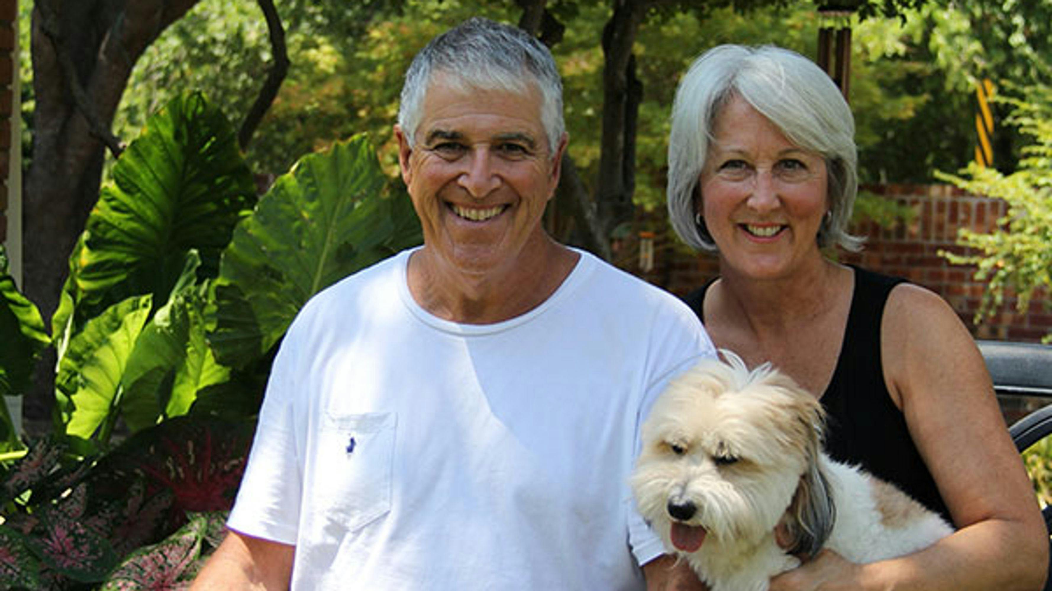 A middle-aged man and woman with a cute dog